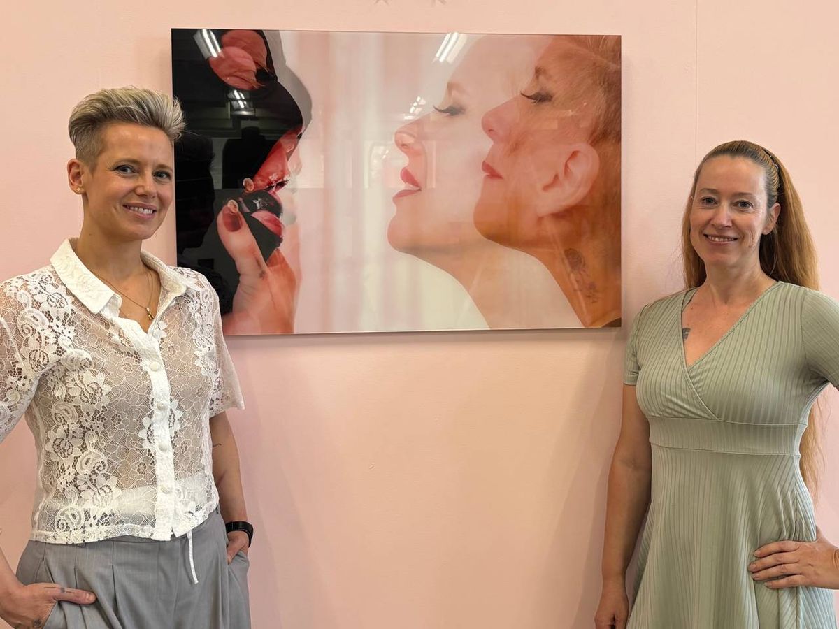 Hanneke Wetzer and Mistress Eve standing in front of the photographic work Intimiteit in Overgave at Sexhibition.