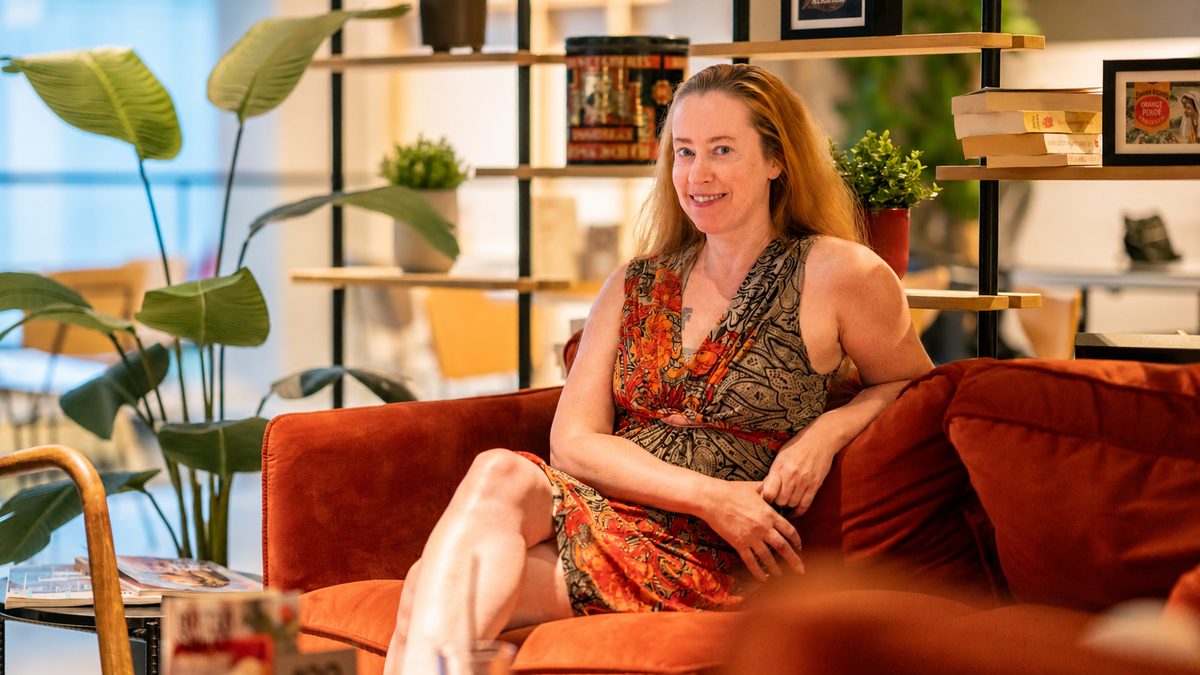 Hanneke Wetzer sitting on an orange sofa during the interview at Douwe Egberts Café in Eindhoven.