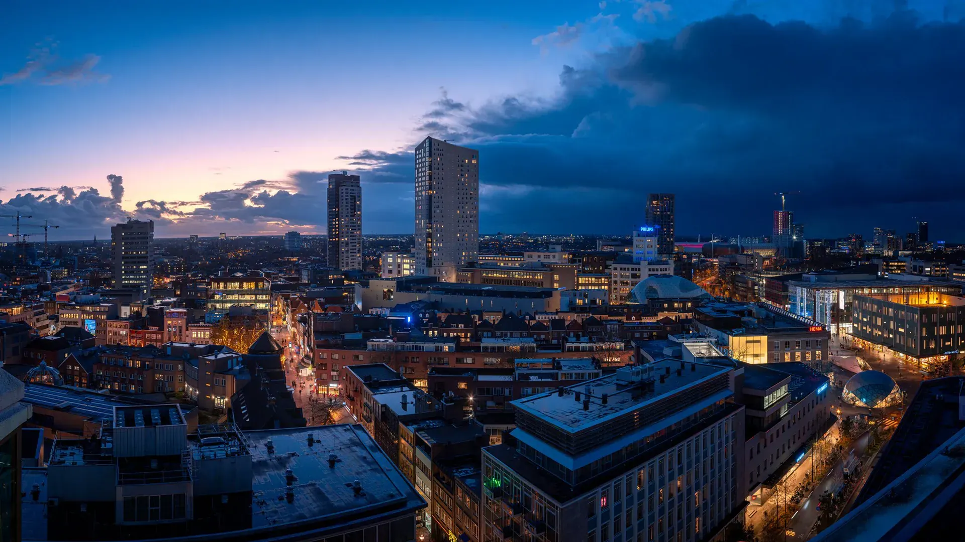 Eindhoven tijdens het blauwe uur met verlichte straten en hoogbouw, gefotografeerd door Jan Timmer.
