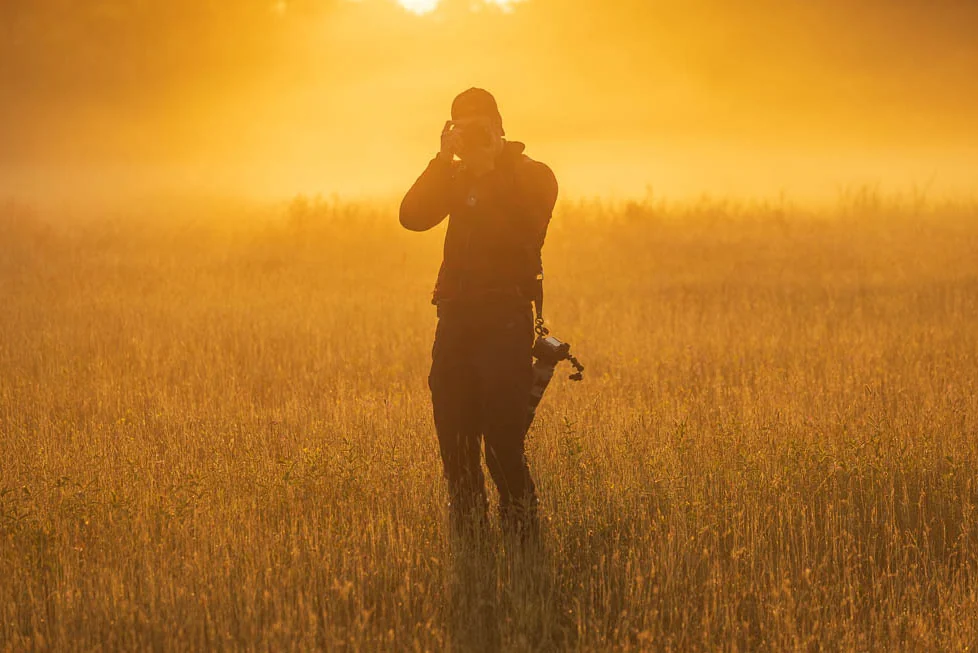 Roy van der Wens fotografeert tijdens golden hour in een veld.