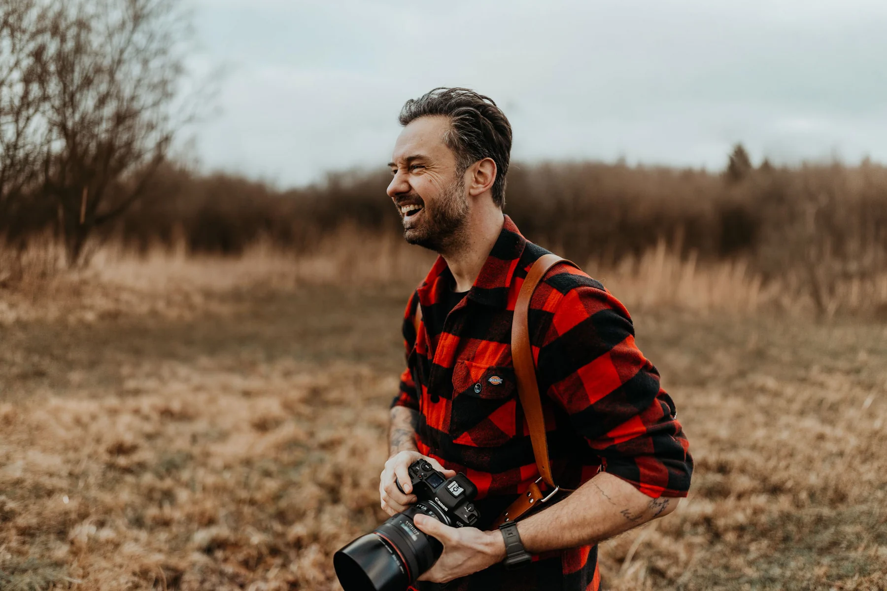 Roy van der Wens met camera tijdens een fotoshoot in de natuur.